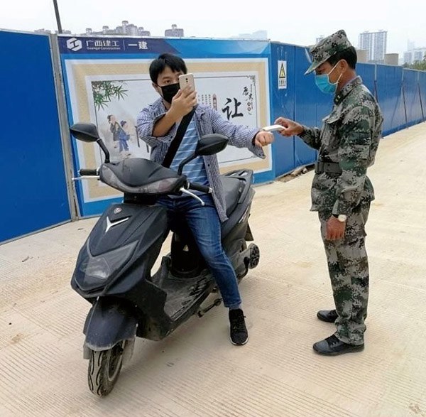 1585039328650201.jpg 安保人員對進(jìn)入校園人員測量體溫.jpg